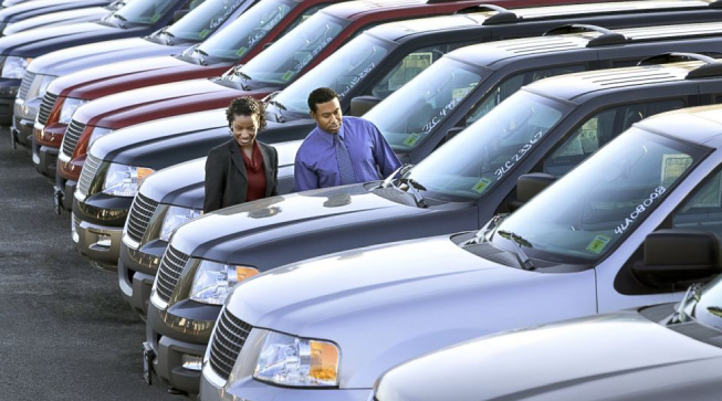 Profession People Looking At The Manufactured Car To Take Up for Dealership Business.